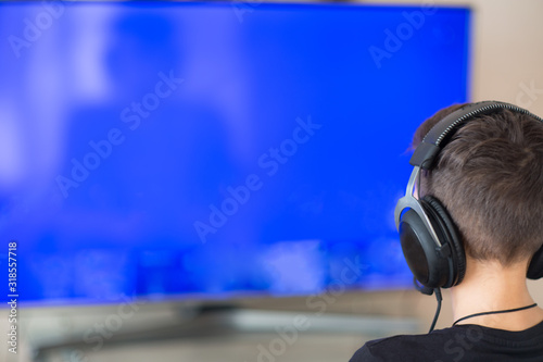 at the TV screen the guy’s head in headphones