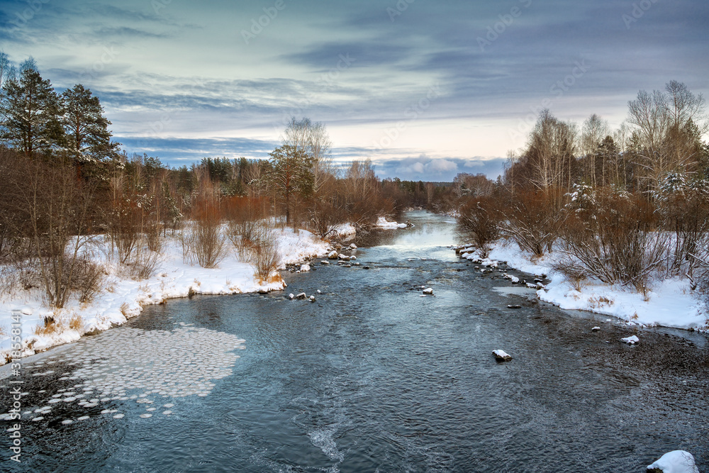 Winter landscape at sunset by a snowy forest lake. Winter forest. Winter landscape at sunset by a snowy forest lake. Winter forest.