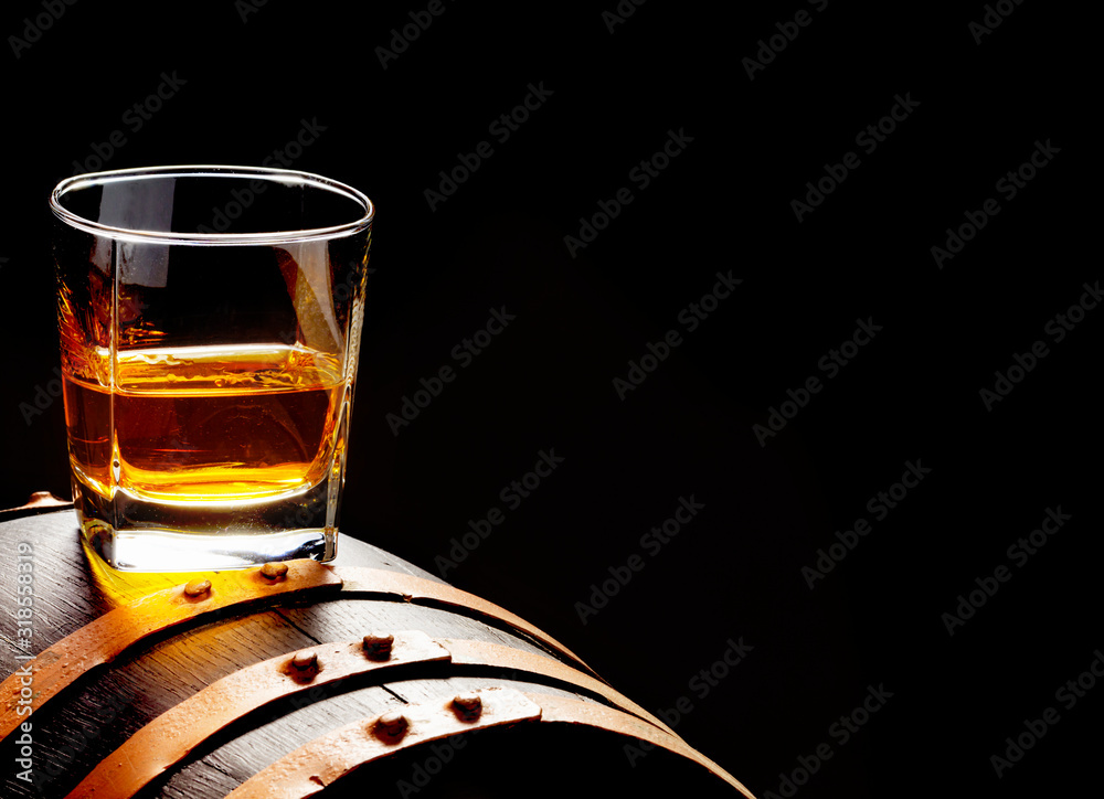 Whiskey sample, whiskey glass stands on a whiskey barrel