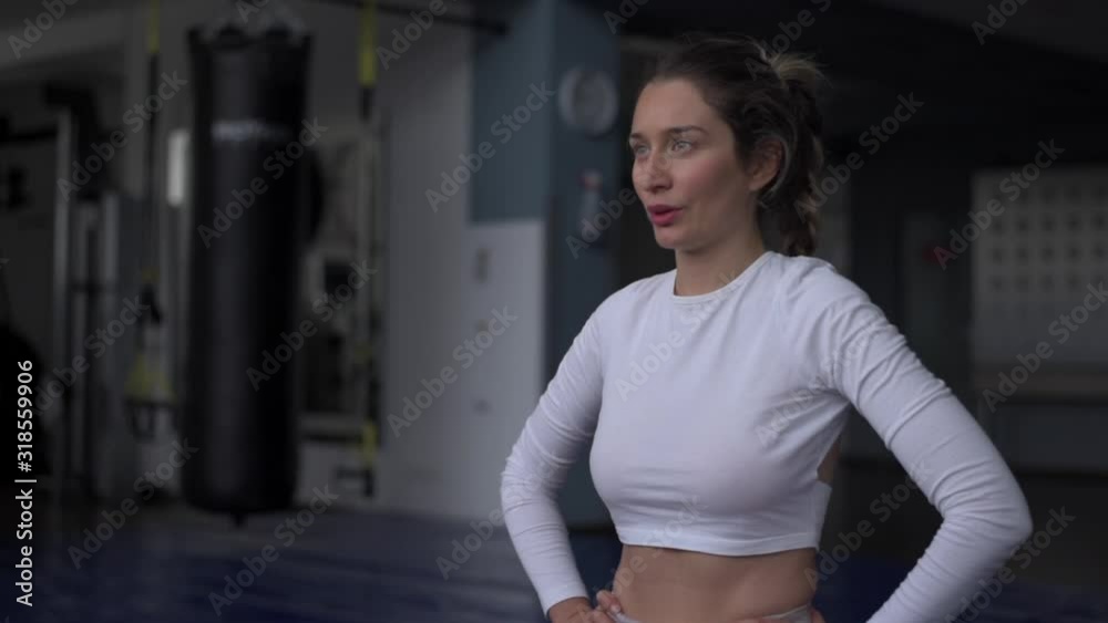 Young caucasian woman exercising and stretching in the gym. Bokeh background. vertical screen