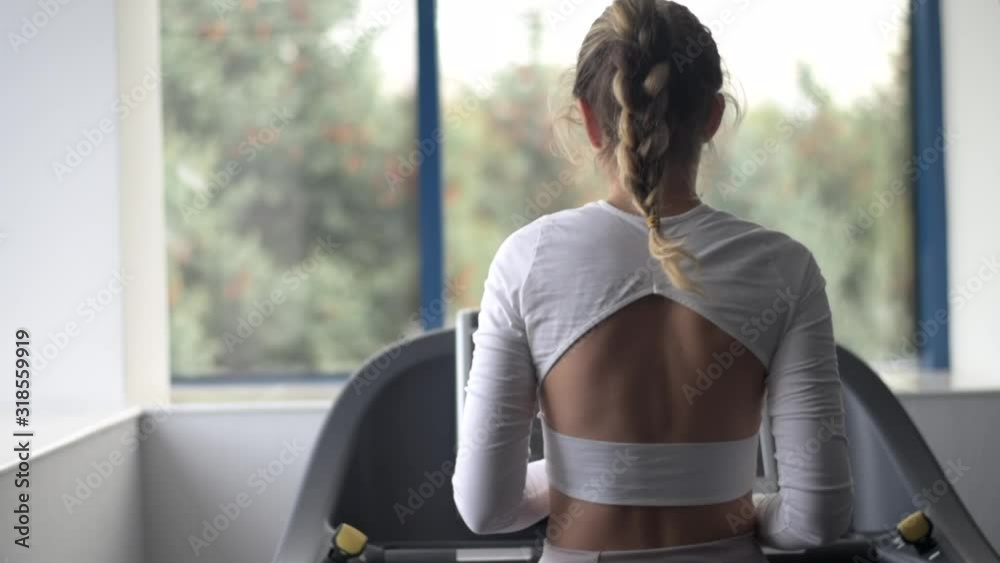 Young caucasian woman exercising and stretching in the gym. Bokeh background. vertical screen