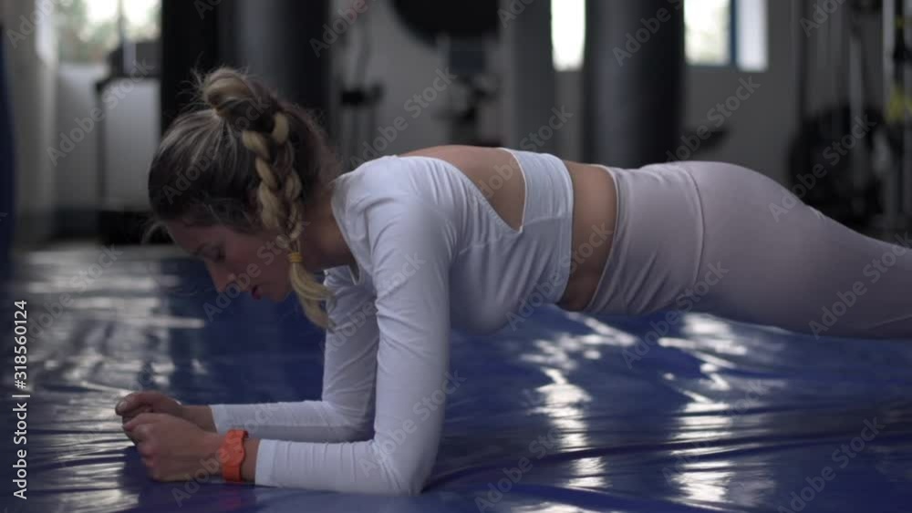Young caucasian woman exercising and stretching in the gym. Bokeh background. vertical screen