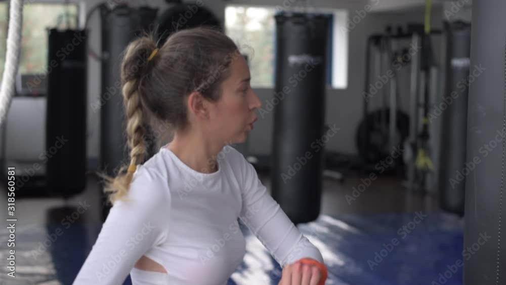 Young caucasian woman exercising and stretching in the gym. Bokeh background. vertical screen