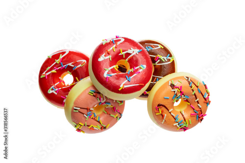 Colorful glazed doughnuts with sprinkles isolated on white background.