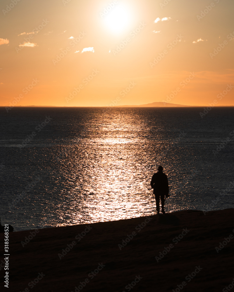 Silhouette of man looking at the sea