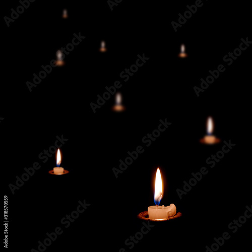 Eight candles burning in the dark. The candles almost burned out. Many candles in the dark