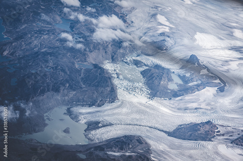 Greenland, aerial view of glacier and snow covered mountains. This is a consequence of the phenomenon of global warming. The view from the plane. Photo taken in Greenland.