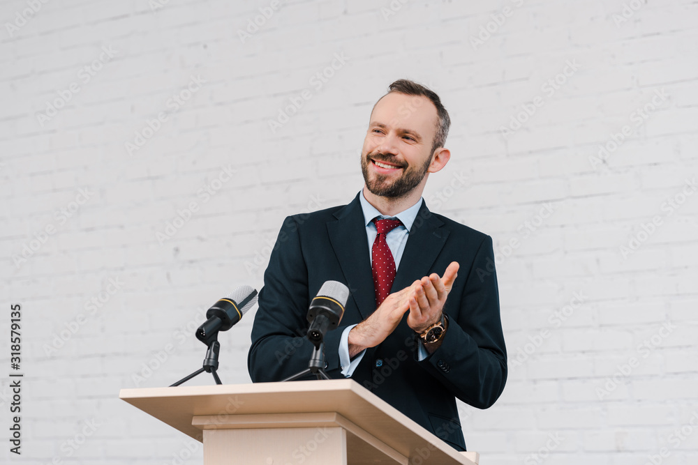 happy bearded speaker applauding near microphones happy bearded speaker applauding near microphones