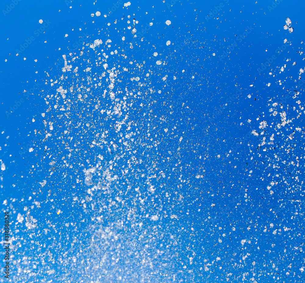 Splashing water from a fountain on a background of blue sky Splashing water from a fountain on a background of blue sky