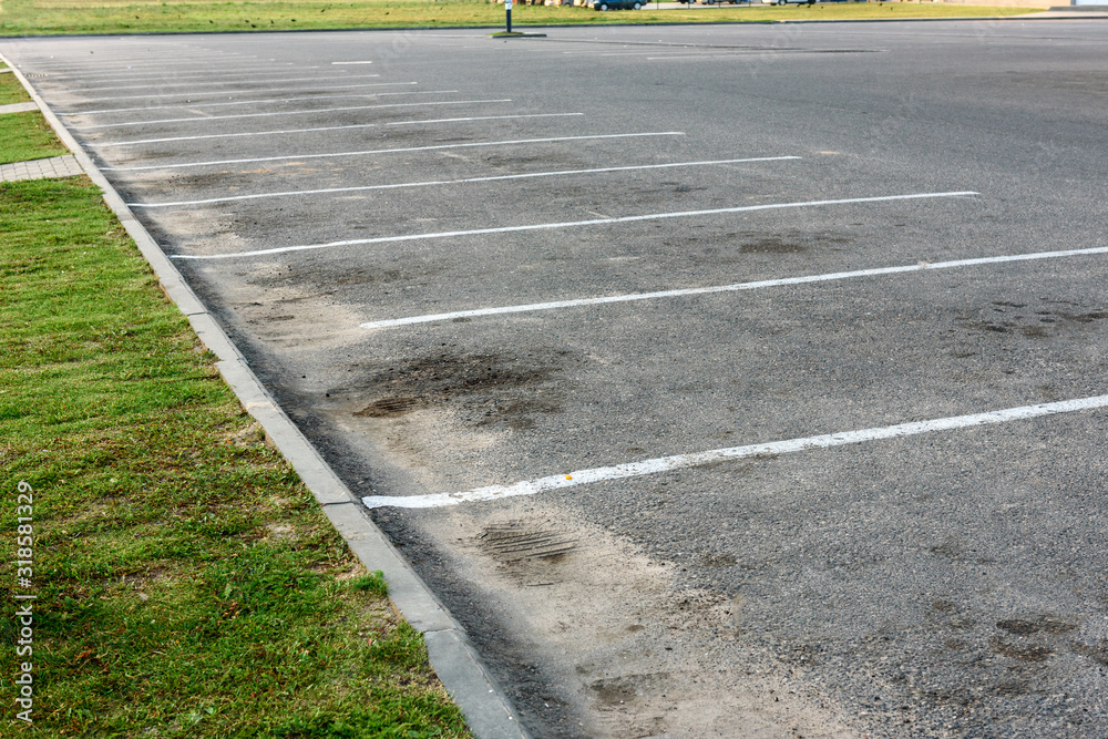 Obraz premium Empty outdoor dirty parking lot space marked with white lines.