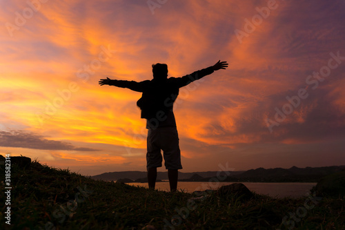 silhouette of Happy man on top of mountain
