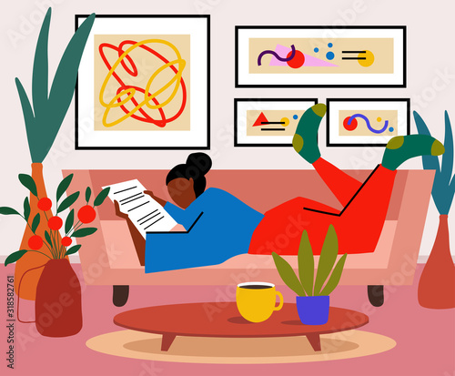 Lonely woman sitting on sofa in her room and reeding newspaper or book. Weekend or free time spending. Young girl chilling out with cup of tee or coffee.