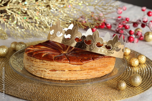 Epiphany kings galette with a golden paper crown and one small porcelen charm inside. 