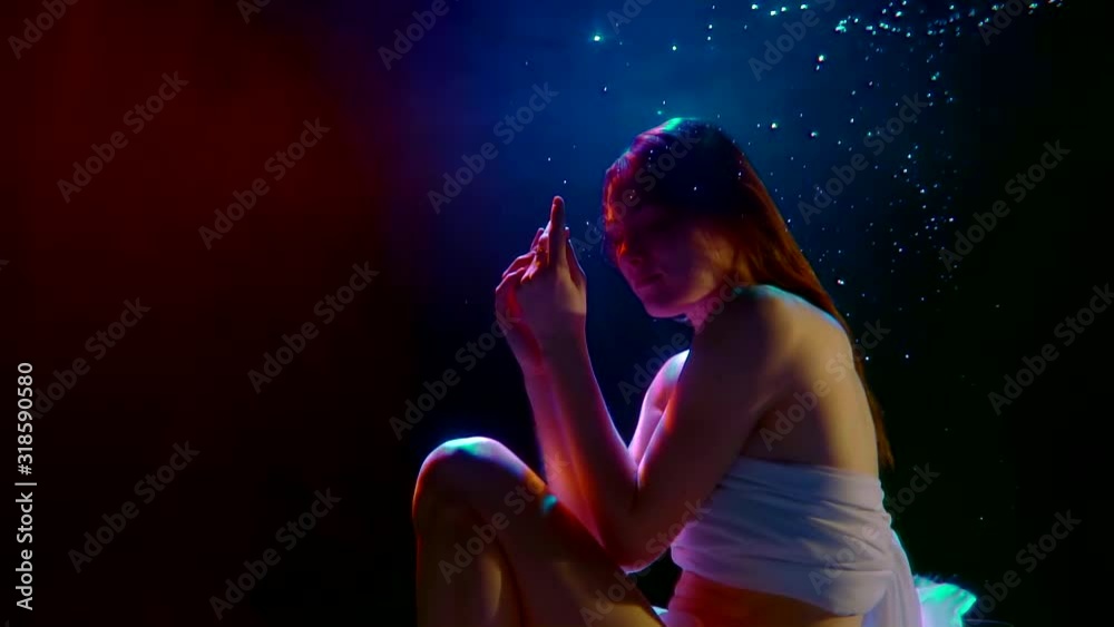 female model is floating inside dark water of swimming pool, underwater shot in slow motion female model is floating inside dark water of swimming pool, underwater shot in slow motion