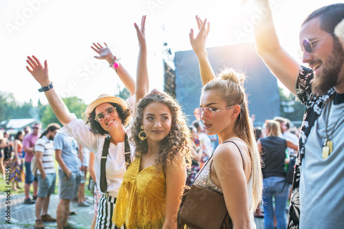 Front view portrait of group of young friends dancing at summer festival.