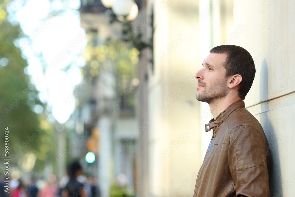 Pensive adult man looking away in the street Pensive adult man looking away in the street