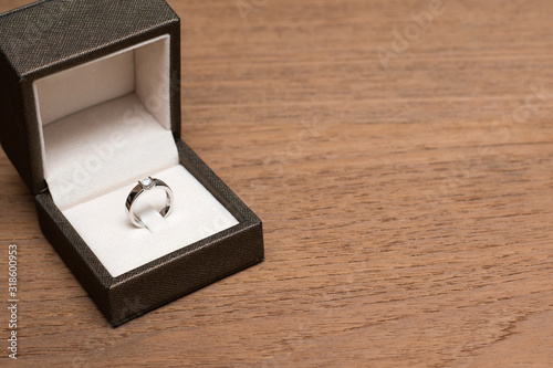 Diamond wedding ring in the box on wooden table. © Aonprom Photo