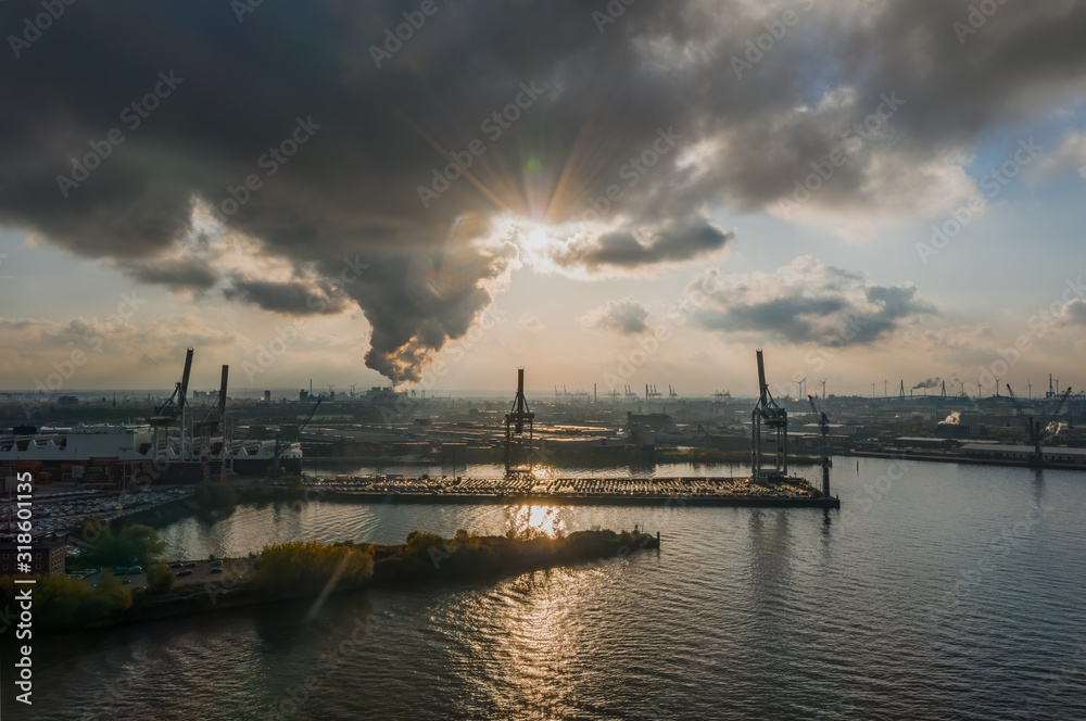 Aerial view of sunset over heavy lifting in port of Hamburg HafenCity city during sunset with heavy clouds