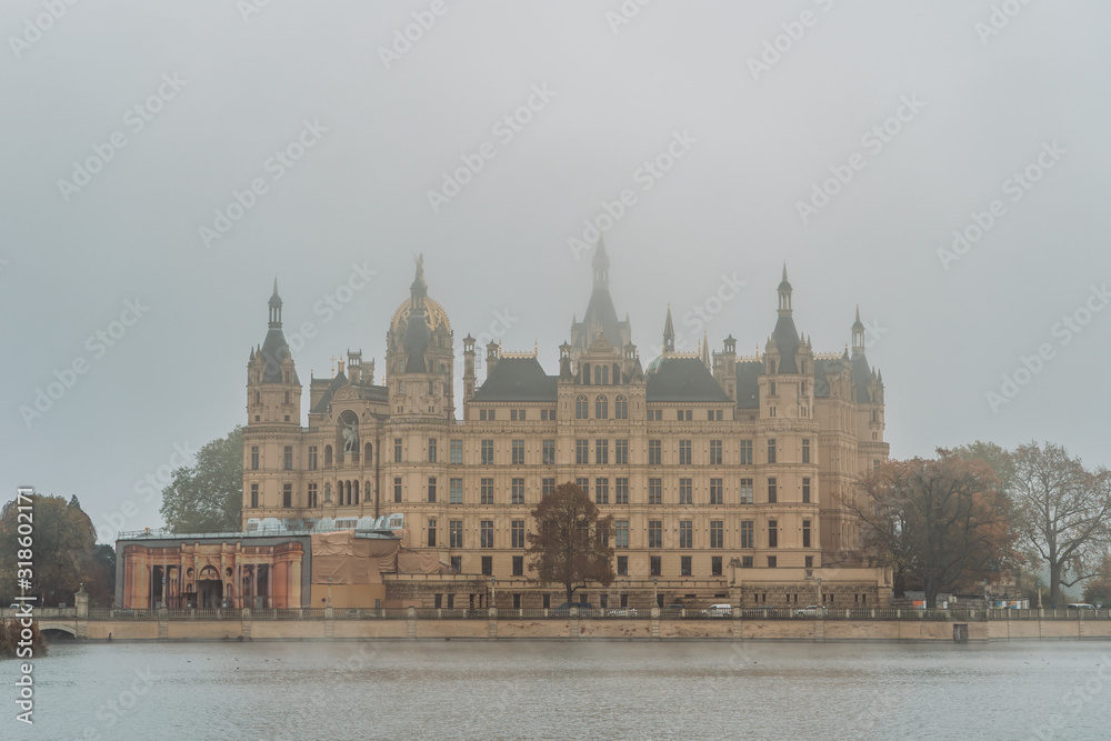 Lake view of Side facade of Schwerin Castle Palace with heavy fog and haze in the morning