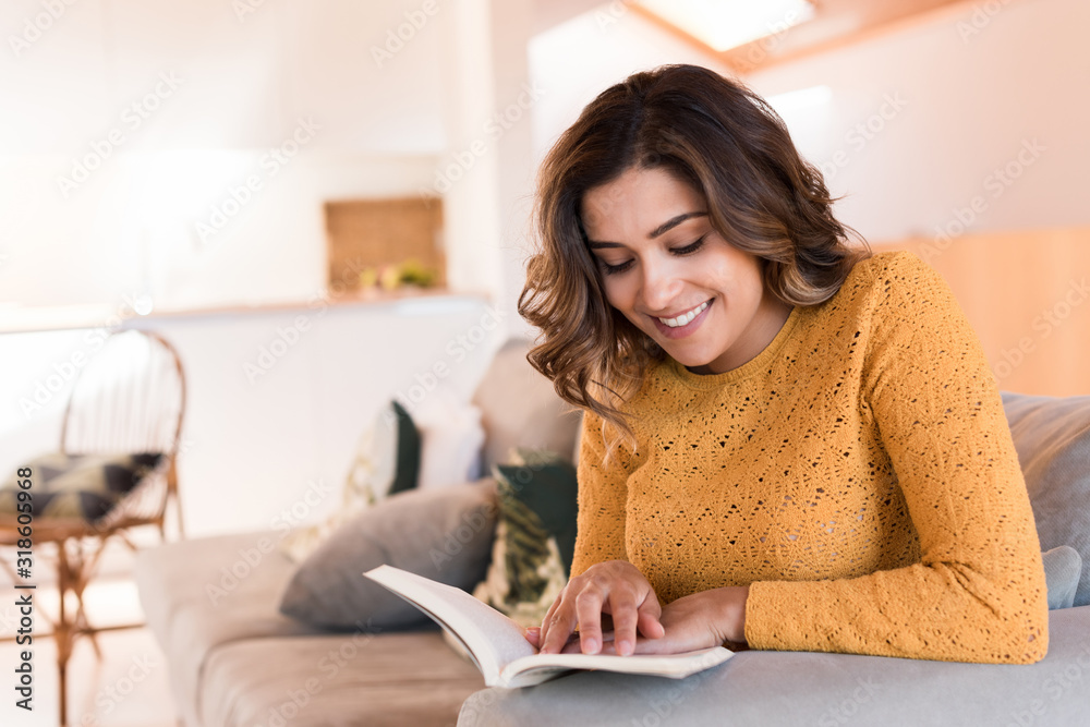 Woman reading book on sofa Woman reading book on sofa