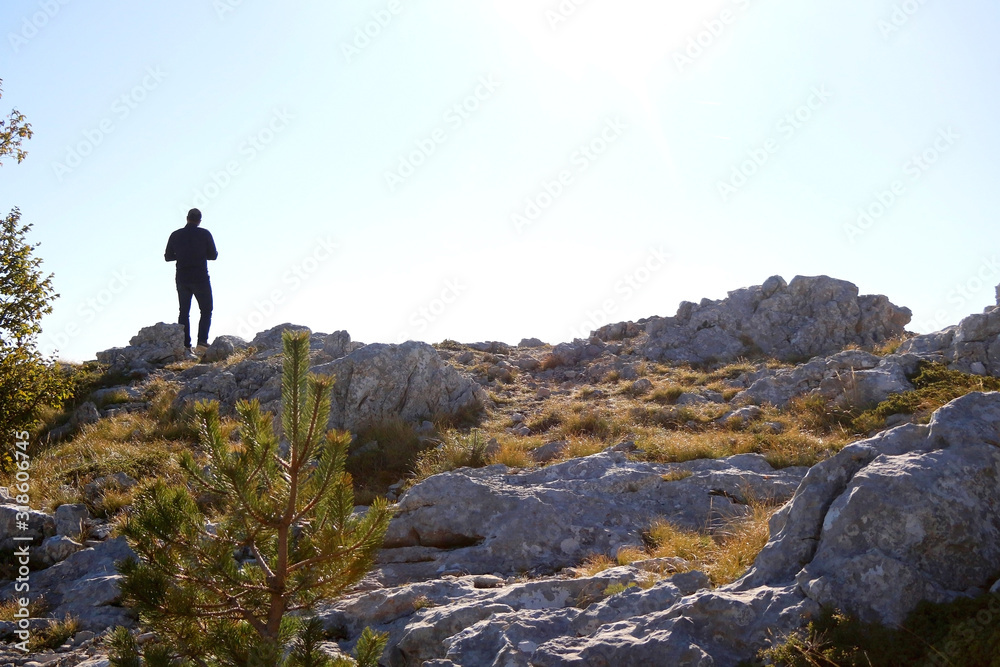 Silhouette of an unrecognizable man hiking on mountain Biokovo in Dalmatia, Croatia on a sunny day.