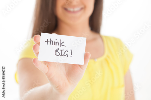 Think big! Smiling female holding business card that encourages following your dreams