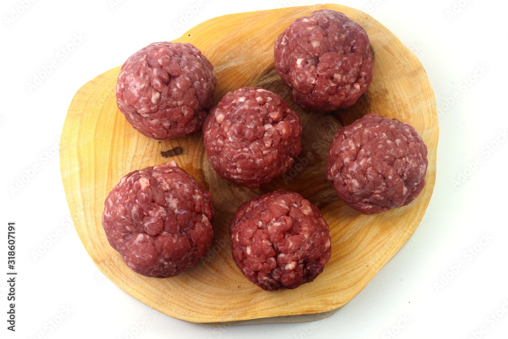 closeup fresh raw meatballs beef isolated over white background on rustic wooden board closeup fresh raw meatballs beef isolated over white background on rustic wooden board