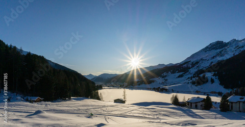 winter mountain landscape and frozen lake at sunset photo