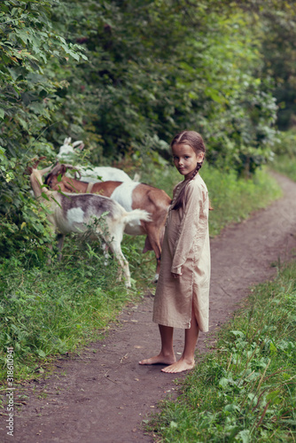 Tablou canvas Little girl goatherd in forest