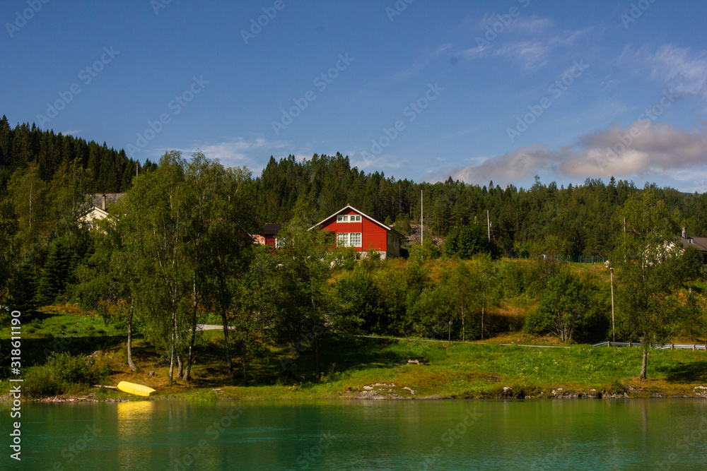Obraz premium View of the turquoise lake. In the distance can be seen the mountains, boat and house