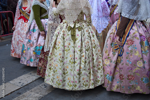Group of falleras dressed in regional costume at the exit of the Ofrenda (floral Offering) to the Virgin Mary in Valencia, Spain