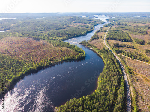 View of Kalix river  Kalixalven  Overkalix locality and the seat in Norrbotten county  Sweden  with forest in sunny summer day  aerial drone view