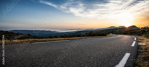 Fotografia Empty long mountain road to the horizon on a sunny summer day at bright sunset