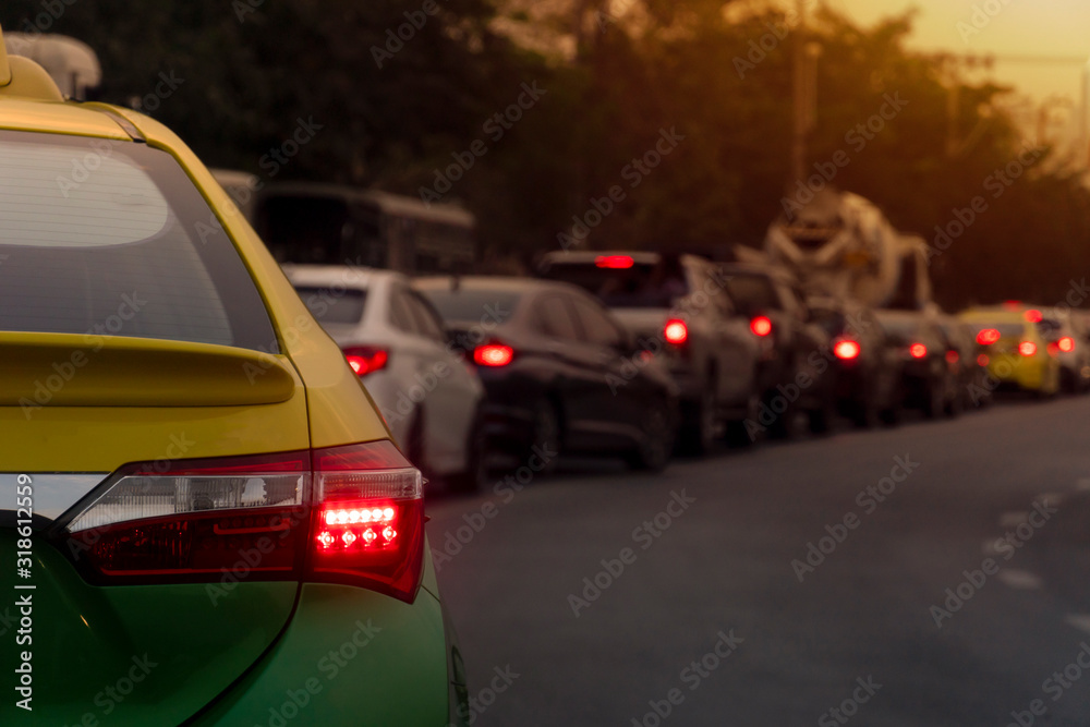 Luxury of Taxi car stop on the asphalt road. Getting around in the city in the evening. Open light brake. With tree and city. Traffic jam after to work in an urban area.