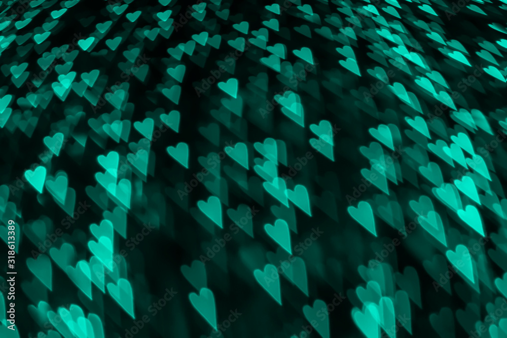 Blurred creative mint color lights in the shape of hearts on a black background. Abstract modern trendy texture backdrop. Bokeh light. Blurred creative mint color lights in the shape of hearts on a black background. Abstract modern trendy texture backdrop. Bokeh light.