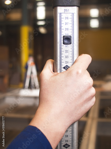 An apprentice engineer using a digital measuring device to inspect and measure a recently welded metal object. precision measurement is required with mechanical parts. industrial rulers 