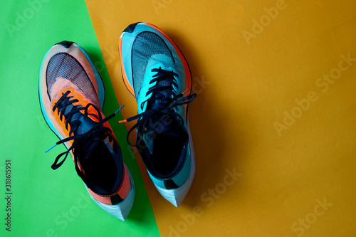 Blue and orange running shoes on green floor with copy test space,top photo