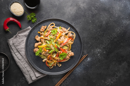 Udon with pork and vegetables on black background. Asian cuisine.