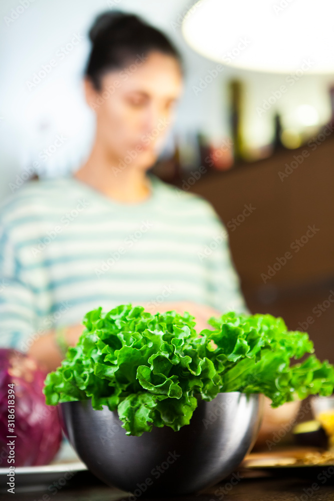 Girl in the kitchen prepares the salad