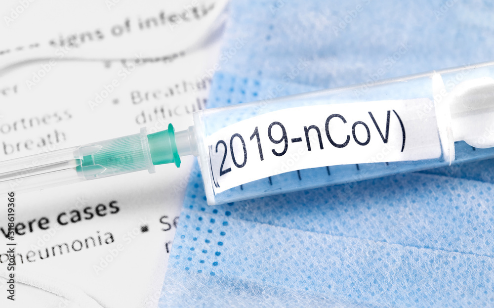 Obraz premium Novel coronavirus (2019-nCoV). Respirator masks, syringe with text (2019-nCoV) on papers background closeup