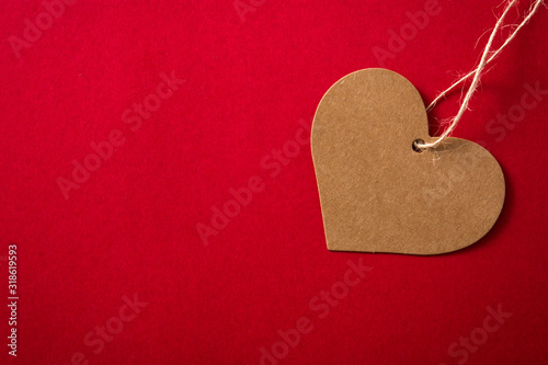 Brown heart-shaped label on red background. Copy space
