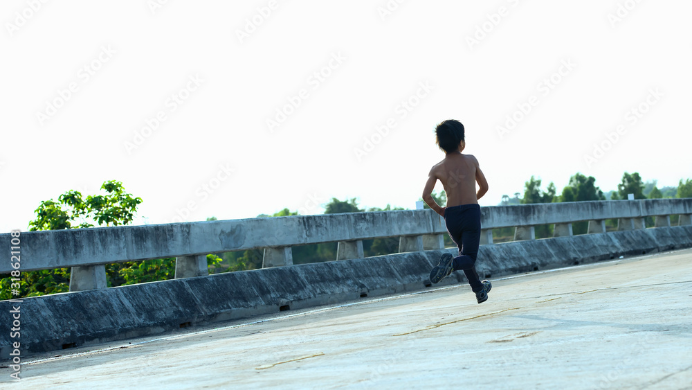 A little boy runs along the bridge on the beach.