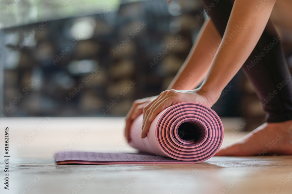 Naklejka premium Close-up rolling yoga mat after working out at fitness ,sport and training club.Diversity People Exercise Class Relax Concept