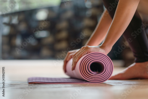 Close-up rolling yoga mat after working out at fitness ,sport and training club.Diversity People Exercise Class Relax Concept