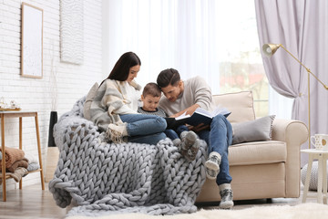 Happy family with little son reading books at home. Winter vacation