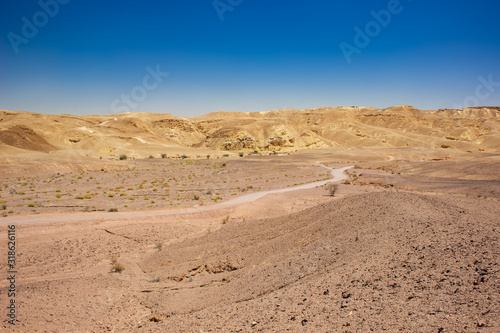 desert landscape sand stone ground dry wasteland scenic view rocky hills horizon background Middle East Israeli warm region