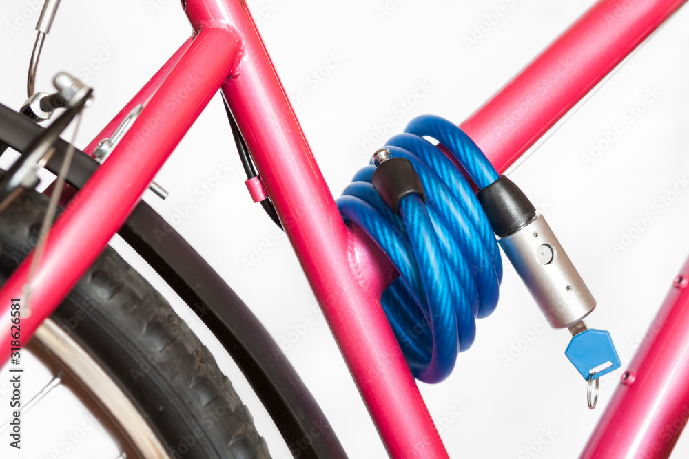 Simple cable lock with padlock is on pink bike frame, white background