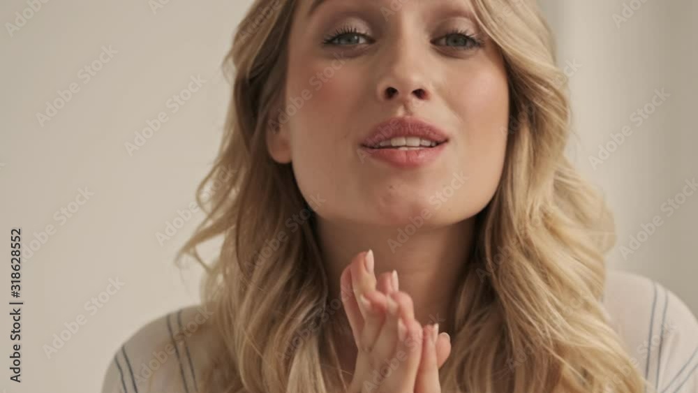 Close up view of nice woman with crossed fingers doing a praying gesture in the white studio Close up view of nice woman with crossed fingers doing a praying gesture in the white studio