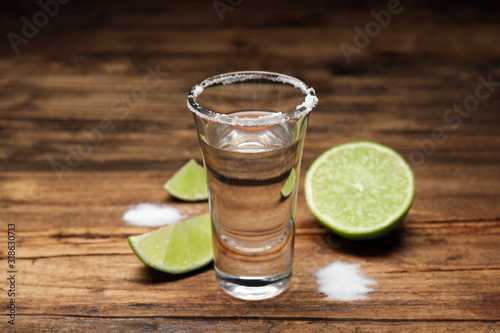 Mexican Tequila shot with salt and lime on wooden table