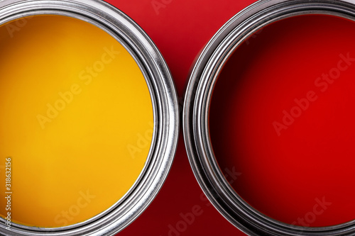 Fototapeta Naklejka Na Ścianę i Meble -  Cans of yellow and red paint on red background. Top view, minimal styled.